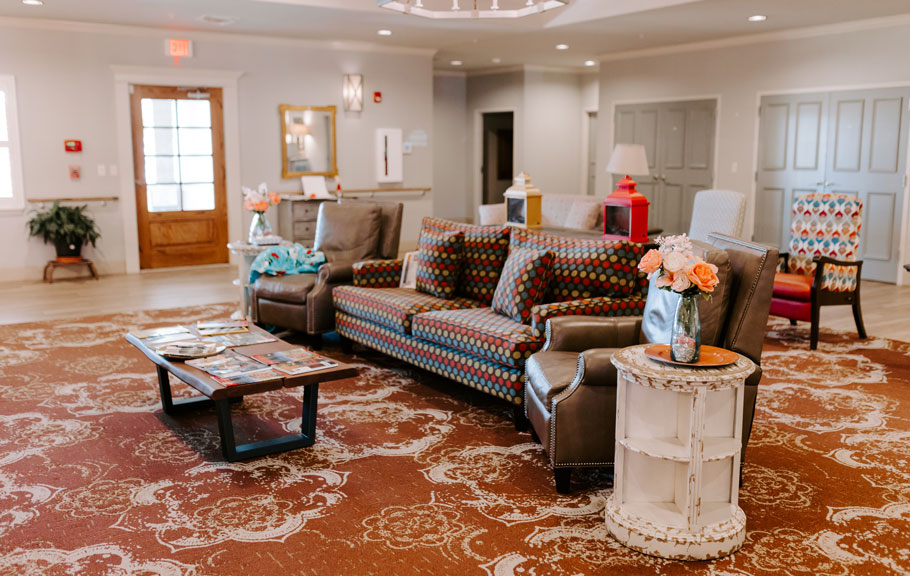 Spacious common room with comfortable couches and chairs for residents